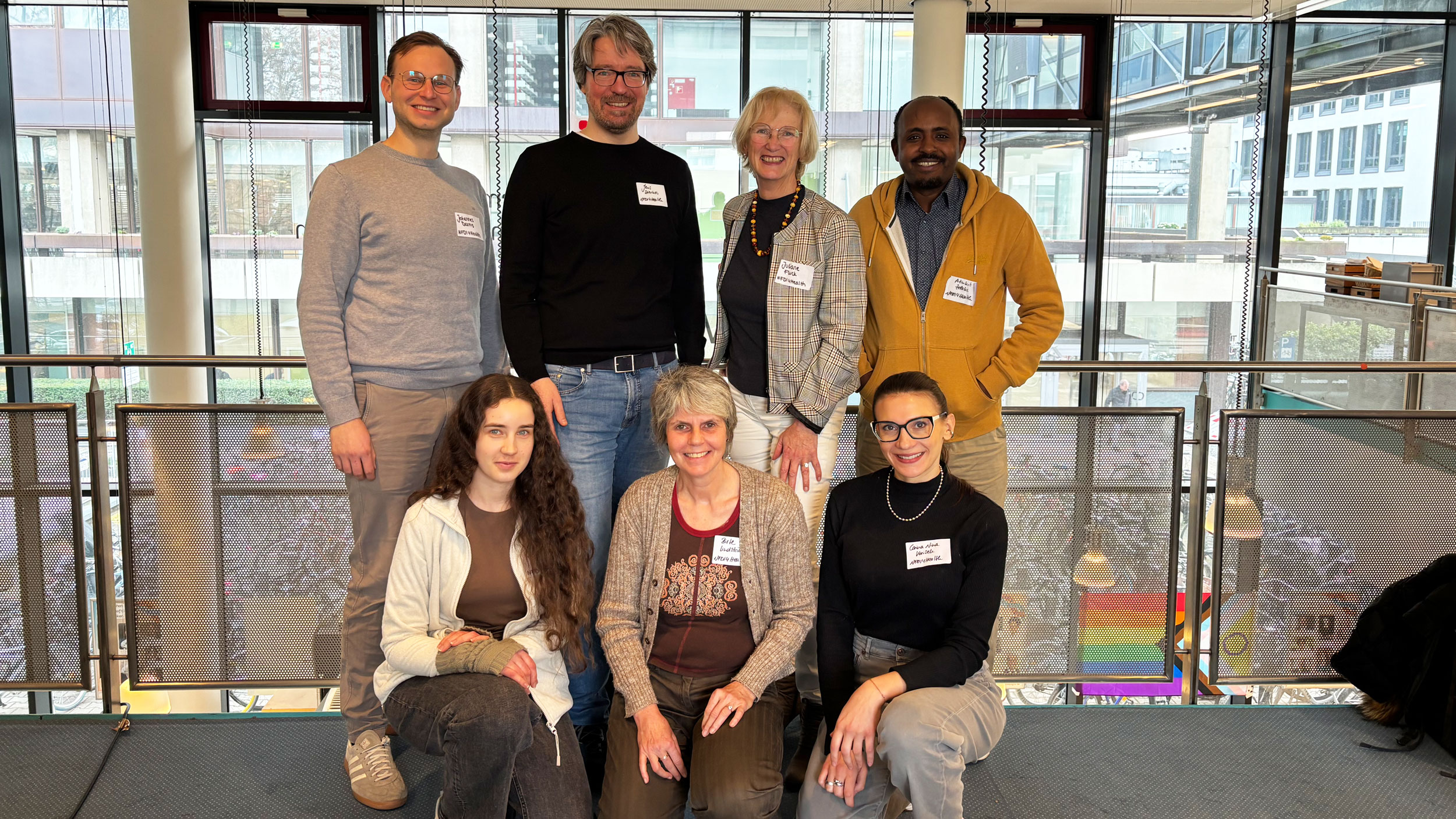 Sieben Mitglieder von NFDI4Health stehen in einem Flur. 