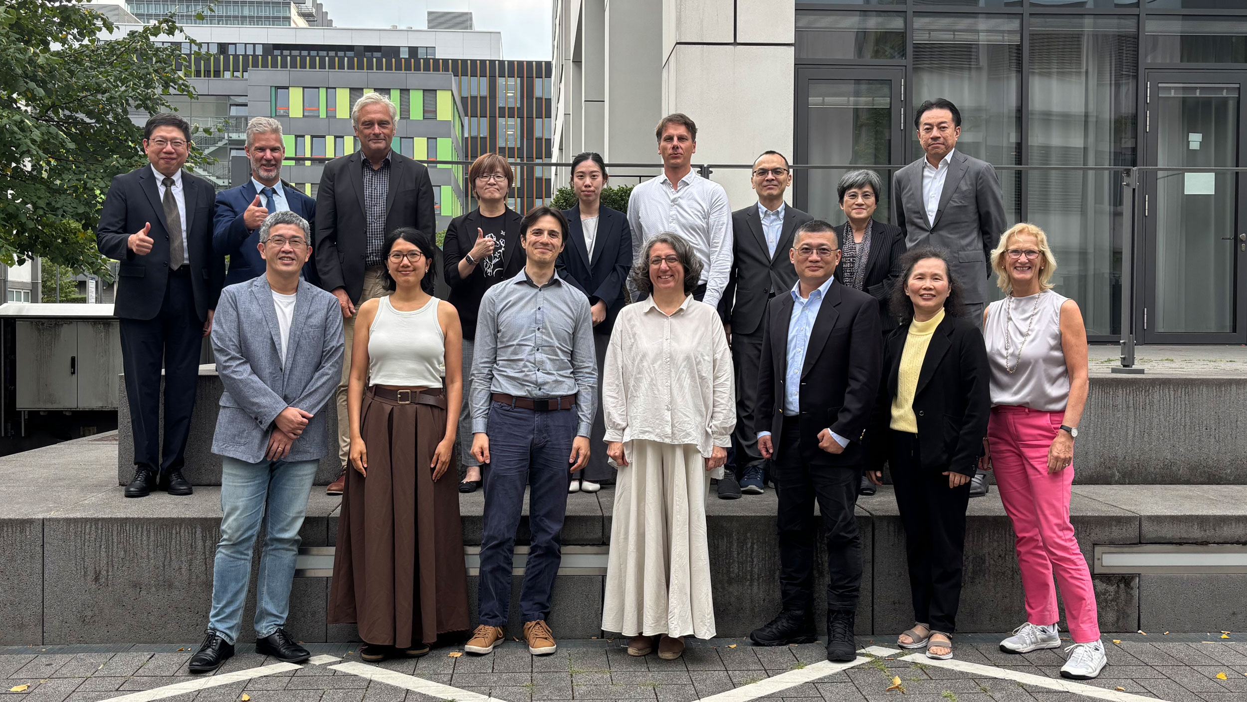  Gruppe aus etwa 20 Expertinnen und experten vor einem Gebäude. 